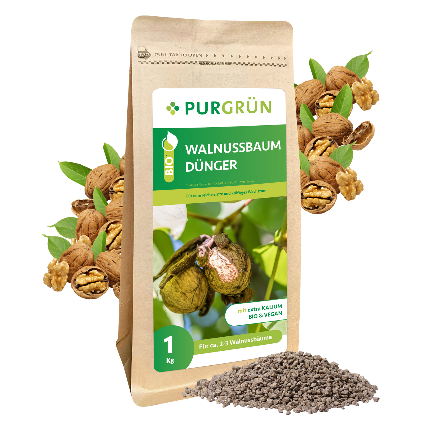 Ein 1-kg-Beutel Purgrün Bio-Walnussbaum-Dünger steht aufrecht. Auf dem Etikett ist ein Walnusszweig abgebildet. Davor liegt ein Haufen Düngergranulat, im Hintergrund sind Walnüsse und Kerne zu sehen.