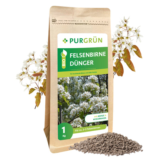 Auf der Verpackung ist ein 1 kg Sack Purgrün Bio-Felsenbirne-Dünger mit blühenden Elsbeerblüten abgebildet, umgeben von körnigem organisch-mineralischem Dünger und Elsbeerzweigen. Geeignet für den ökologischen Landbau.