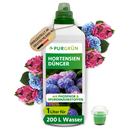 Eine 1-Liter-Flasche Purgrün Hortensiendünger mit einer grünen Kappe und Hortensienblüten auf dem Etikett. Dahinter blühen rosa und blaue Hortensien, daneben ein Messbecher und das Etikett "Hergestellt in Deutschland".